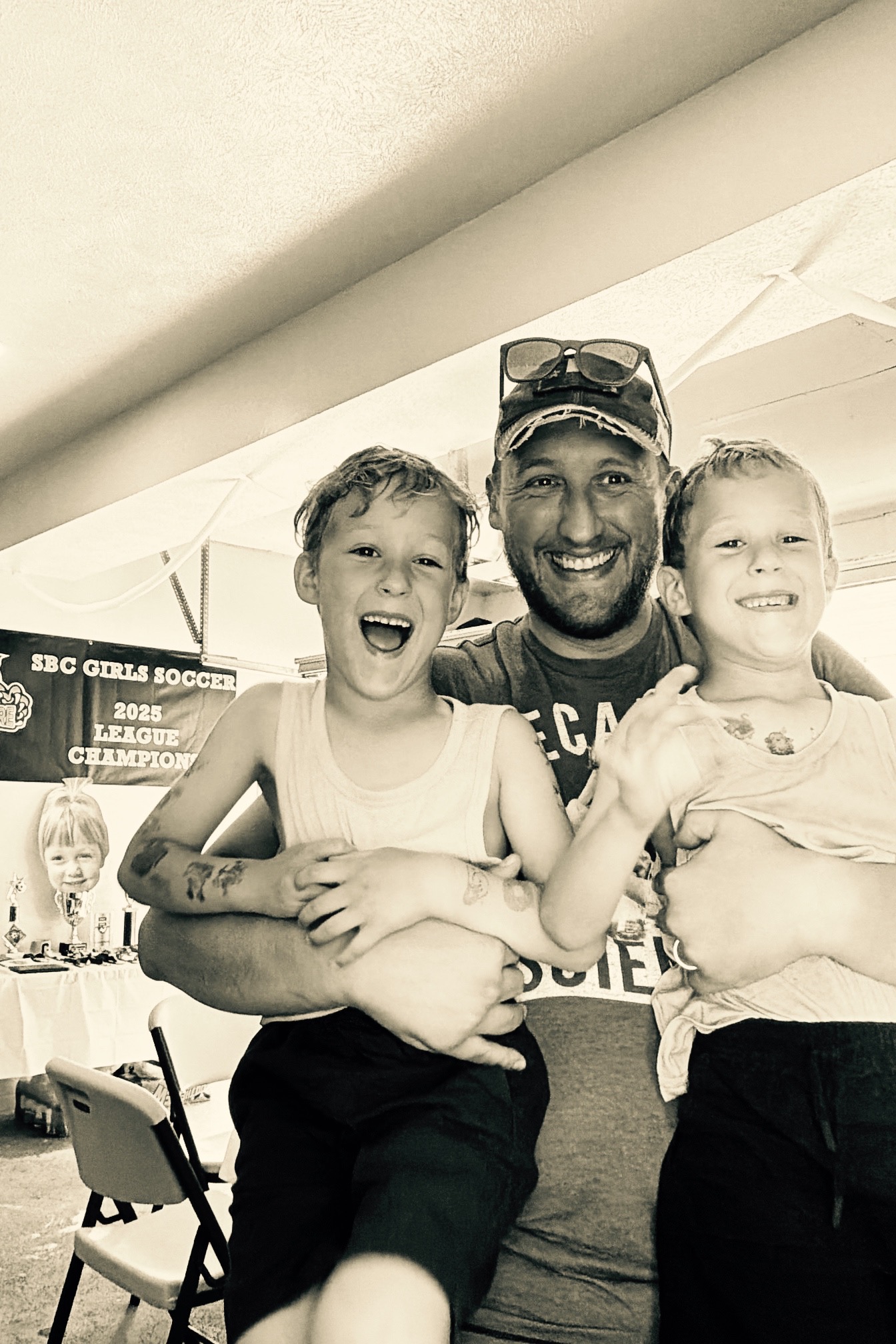 A dad laughing with two kids in a family celebration photo booth capture.