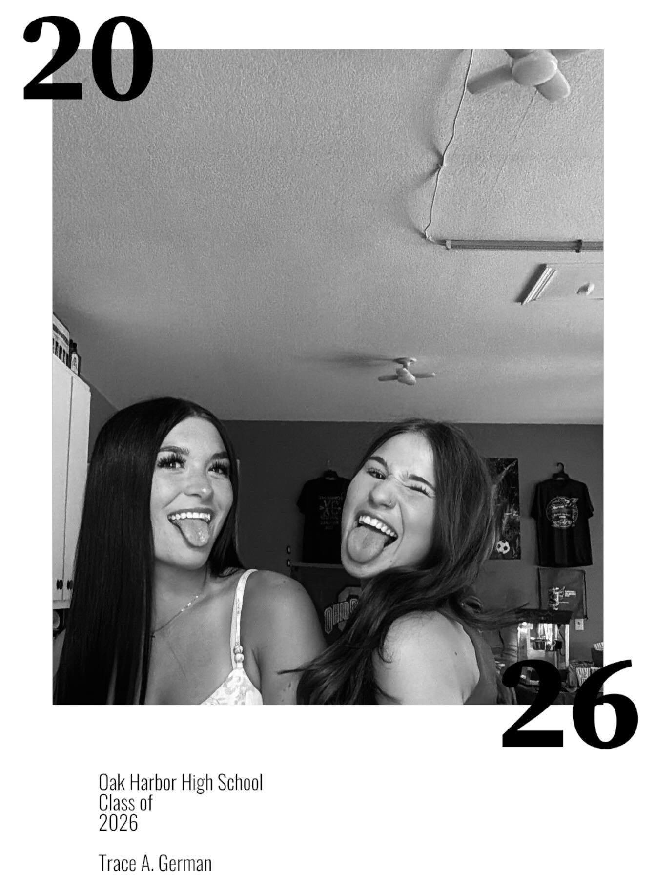 Two graduation party guests laughing in a black and white photo booth capture.