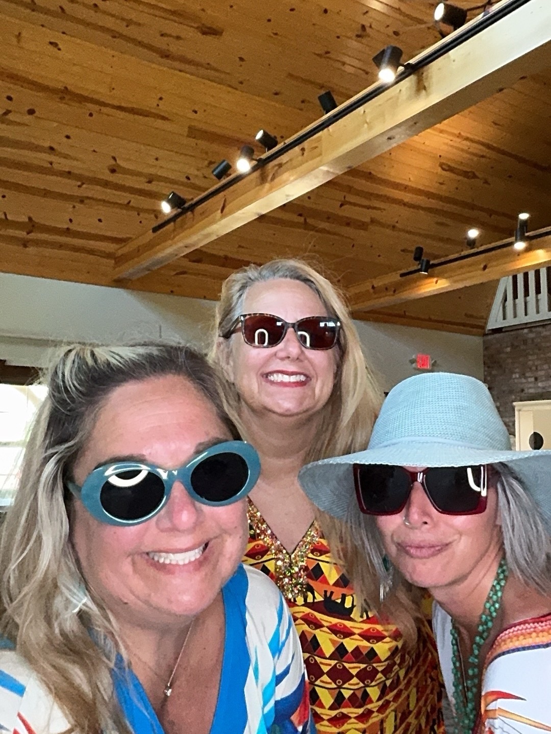 Three adult party guests wearing sunglasses and posing in a Frank Creations photo booth capture.